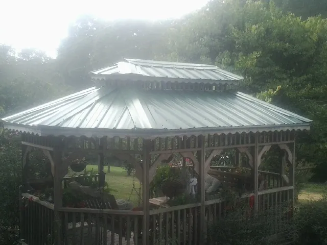 Two tier green metal roof on a garden gazebo in Ona