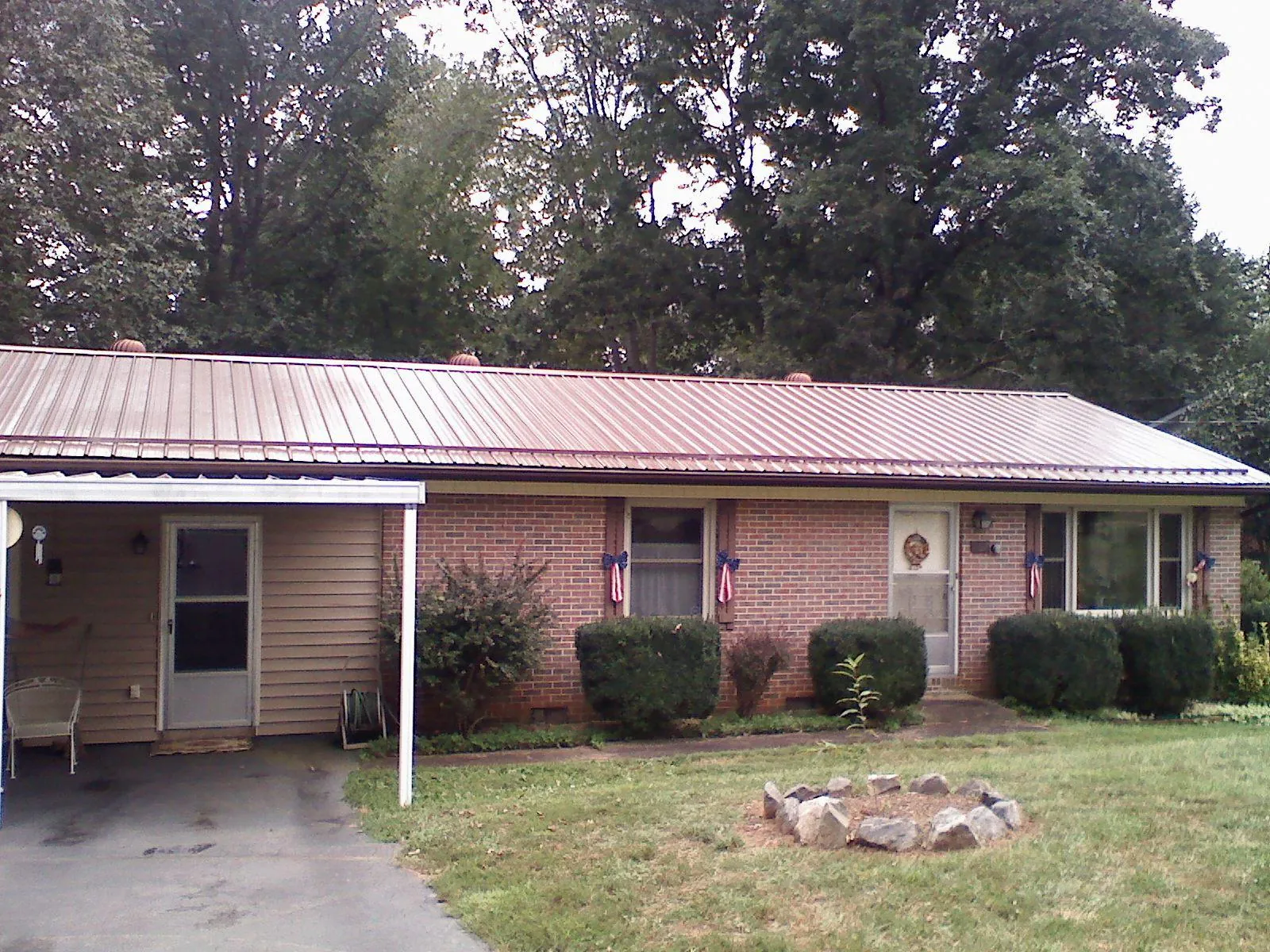 Bronze metal roof and carport on a brick ranch home — Roof Repair work by our crew in Ona